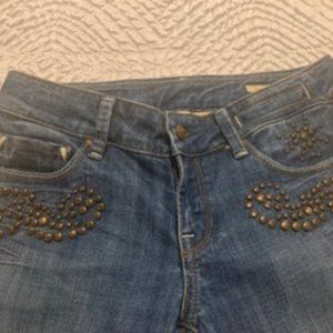 Medium wash boot stretch jeans with brass embellishments